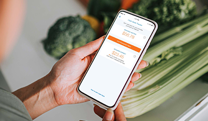 Woman on phone looking at cash back rewards with groceries