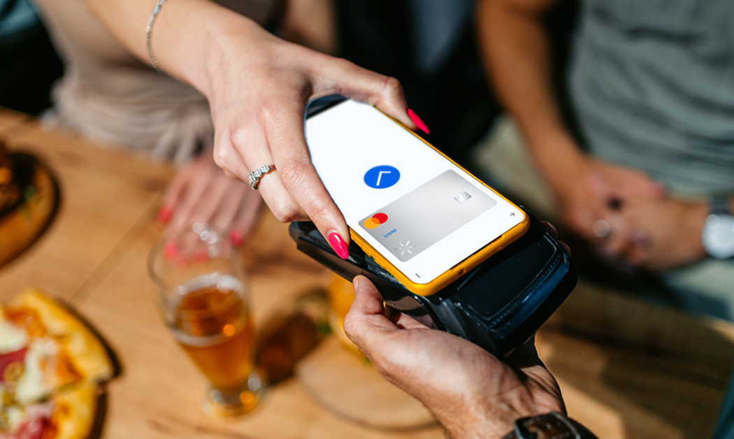 Woman paying with her virtual Walmart MoneyCard account on her smartphone at a restaurant.